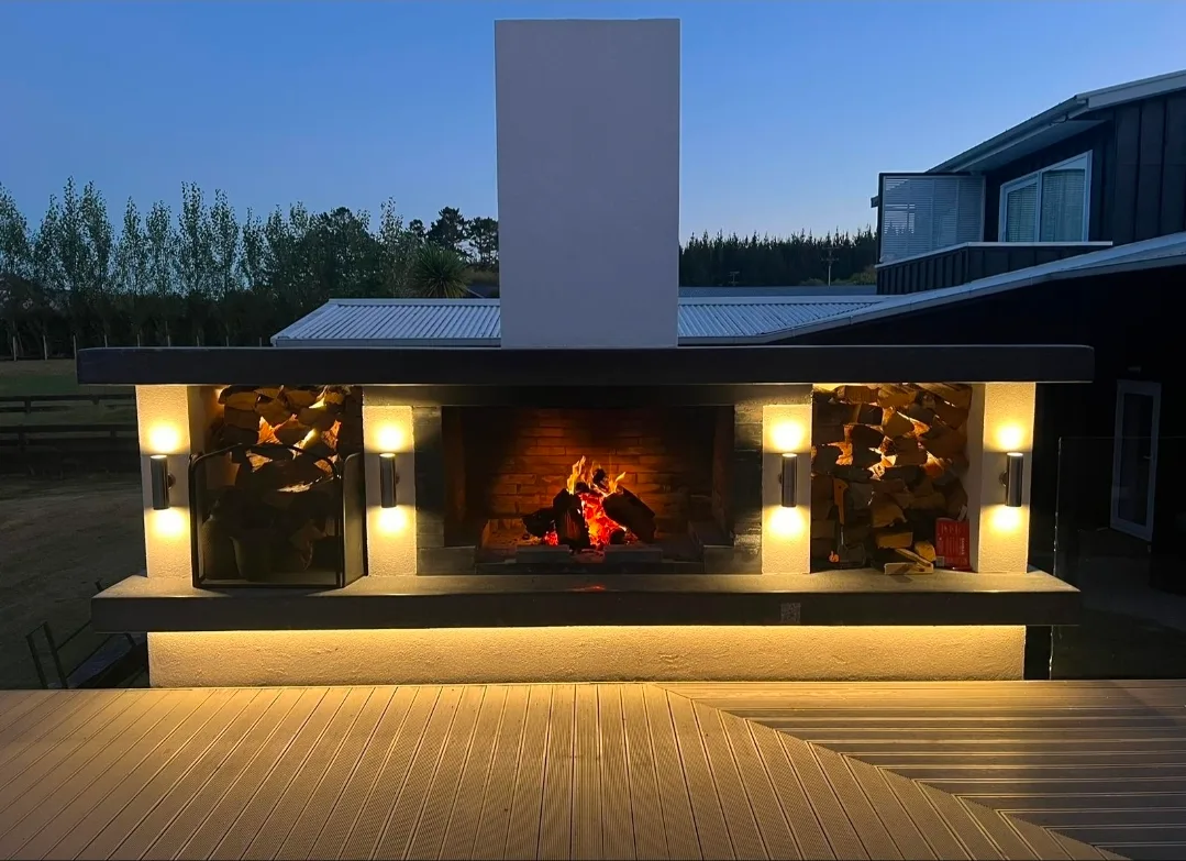 Outdoor fireplace with wall uplighting installed by Westside Electrical